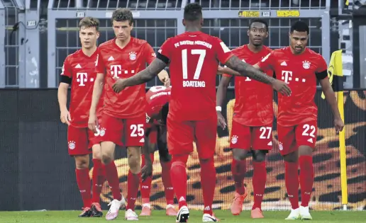  ??  ?? Bayern Munich players celebrate scoring a goal during a Bundesliga football match between Borussia Dortmund and Bayern Munich, in Dortmund, Germany, May 26, 2020.