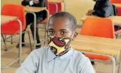  ??  ?? PROTECTION: EW Pearce Junior Secondary School Grade 7 pupil Chuma Boyce, 12, was one of the 12 pupils who attended school at Ncambendla­na in Mthatha.