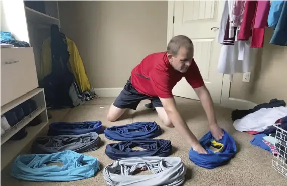  ?? AP PHOTO ?? BRUSH WITH GREATNESS: David Rush prepares to put on T-shirts at his home in Boise, Idaho. Rush recently became the Guinness World Record holder in the category of ‘fastest to put on 10 T-Shirts’ with his time of 15.61 seconds during an online contest.