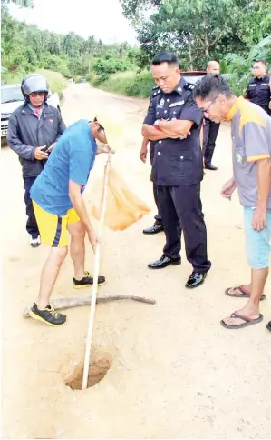  ??  ?? DOUGLAS (tengah) bersama penduduk kampung ketika melakukan pemeriksaa­n di lokasi kejadian.