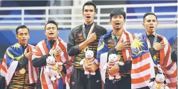  ?? — Reuters photo ?? Malaysia’s sepak takraw players react on the podium during the medal ceremony.