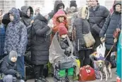  ?? VISAR KRYEZIU AP ?? People who left Ukraine wait for a bus to take them to a train station in Przemysl, Poland.