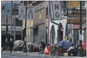  ?? JEFF CHIU — ASSOCIATED PRESS FILE ?? Tents line a sidewalk on Golden Gate Avenue in San Francisco on April 18, 2020. Gov. Gavin Newsom’s goal is to have new homes on public land to house people living in encampment­s along roads and rivers.