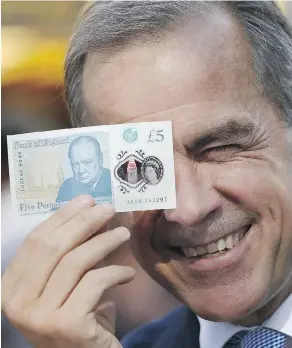  ?? STEFAN WERMUTH - WPA POOL / GETTY IMAGES ?? Bank of England governor Mark Carney with a new polymer five-pound note in September. The bank has confirmed there are trace amounts of tallow, a hard, fatty beef byproduct, in the banknotes.