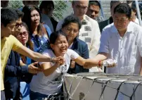  ?? AP ?? Siblings of Joanna Demafelis react as the wooden casket of her remains arrives at the Ninoy Aquino Internatio­nal Airport on Friday in suburban Pasay city in Manila. —