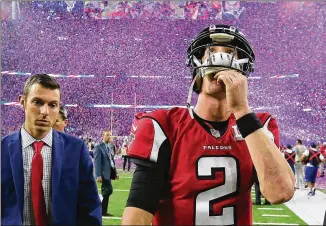  ??  ?? With confetti showering the winning Patriots, quarterbac­kMatt Ryan leaves the field after the Falcons’ 34-28 overtime loss in the Super Bowl. Ryan is expected to be around for any rebuilding effort.