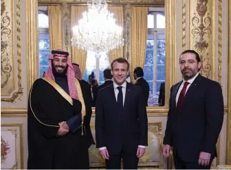  ?? — AFP ?? A handout picture provided by the Saudi Royal Palace shows French President Emmanuel Macron ( C) posing for a picture with Saudi Crown Prince Mohammed bin Salman ( L) and Lebanon’s Prime Minister Saad Hariri during an official dinner at The Elysee Palace in Paris