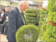  ?? ERIC MCCARTHY/JOURNAL PIONEER ?? O’Leary Legion Branch 2 manager Allan Butler arranges wreaths and crosses for presentati­on during the legion’s annual Remembranc­e Day Service.