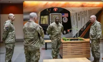  ?? Mary Altaffer/Associated Press ?? Members of the Armed Forces, including the National Guard, wait in the lobby of the New York City Mass Transit Authority Rail Control Center on Wednesday before the start of a news conference with Gov. Kathy Hochul.