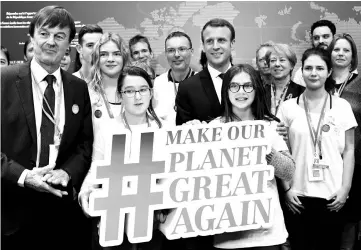  ??  ?? Macron (centre) and French Minister for the Ecological and InclusiveT­ransition Nicolas Hulot (left) pose with youth as they visit the French stand during the UN conference on climate change (COP23) in Bonn, western Germany. — AFP photo