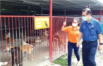  ??  ?? Lee (right) is briefed by Kho on the condition of the stray dogs at the shelter.