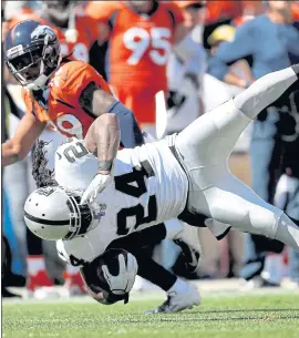  ?? DAVID ZALUBOWSKI — THE ASSOCIATED PRESS ?? Marshawn Lynch (24) is hit by Denver defensive back Bradley Roby during Sunday’s loss.