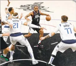  ?? Robert Gauthier Los Angeles Times ?? KAWHI LEONARD drives the lane as the Mavericks converge. Leonard, in his first game since March 31, scored 15 points in the Clippers’ Game 2 loss.