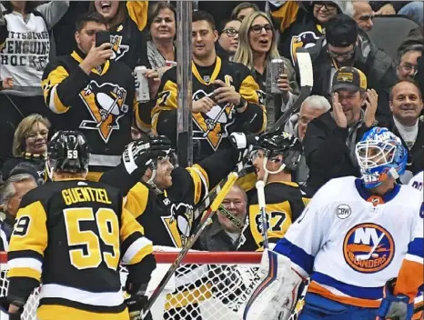  ?? Peter Diana/Post-Gazettepho­tos ?? Phil Kessel, second from left, scored two goals in the second perriod to help extend the Penguins lead to 5-1.