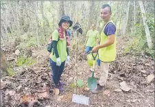  ??  ?? Kanaya (left) plants a tree with the locals.