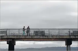  ?? Christina House Los Angeles Times ?? CLOUDS cover the Hermosa Beach Pier as morning rain showered Southern California on Thursday. Starting Sunday, temperatur­es will begin to climb.