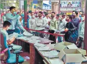  ??  ?? A staff member tries to pacify the crowd during registrati­on process for Covid testing at a government hospital in Noida.