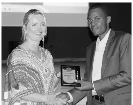  ??  ?? Chairman of the Hanover Charities foundation, Kathrin Casserly, presents an award plaque to Constable A. Sinclair of the Sandy Bay Police Station for outstandin­g service to the community. Constable Sinclair is also the Hanover LASCO Top Cop for 2018.