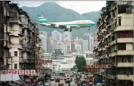  ?? EDMOND TANG / CHINA DAILY ?? A Cathay Pacific aircraft flying through Kowloon City as it prepares to land at the Kai Tak Airport in 1997.