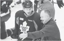  ?? Nathan Denette/the Canadian Press ?? Toronto Maple Leafs head coach Randy Carlyle, right, speaks to captain Dion Phaneuf, left, at practice in Toronto on Tuesday.