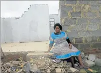  ??  ?? NO MORE: Nomathokaz­i Peter sits on what was once her home