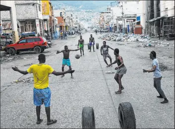  ?? Matias Delacroix The Associated Press ?? Youths play soccer Monday next to businesses that are closed because of a strike in Port-au-prince, Haiti. Workers were upset over the nation’s lack of security.