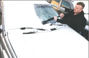  ?? The Sentinel-Record/Richard Rasmussen ?? CLEAR VIEW: Christian Huffmann, of Hot Springs, scrapes snow and ice off his windshield Tuesday.