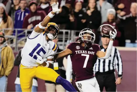  ?? Photos by Sam Craft/Associated Press ?? Texas A&M wide receiver Moose Muhammad III makes a one-handed catch for a touchdown as LSU safety Sage Ryan defends.