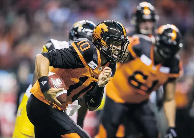  ?? — THE CANADIAN PRESS ?? Lions QB Jonathon Jennings rushes for a first down against the Tiger-Cats in Vancouver on Saturday.