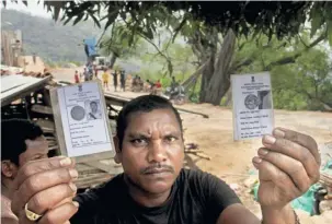  ?? ?? Sundhuru Tadingi displaying his voter cards for both Odisha and Andhra Pradesh at Madkar village, Koraput district, south Odisha.