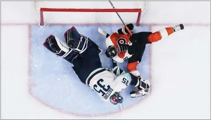  ?? DERIK HAMILTON — THE ASSOCIATED PRRSS ?? The Flyers’ Morgan Frost, right, crashes into Seattle Kraken goaltender Joey Daccord (35) during the second period on Saturday at Wells Fargo Center. The Flyers won, 3-2.