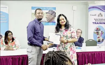  ?? ?? Registrati­on and Licensing Officer in Region 10, Duanne McFarlane (left), receives a certificat­e from Minister of Human Services and Social Security, Dr Vindhya Persaud (Ministry of Human Services photo)