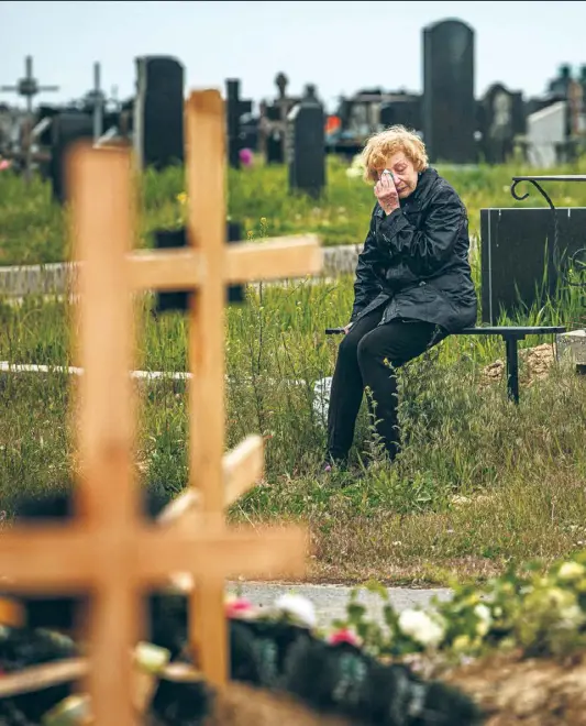  ?? ?? Eine Frau trauert am Grab von Stanislaw Hwostow, 22, der während der russischen Invasion in der Ukraine getötet wurde.