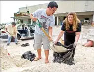  ?? Al Diaz
/
The Associated Press ?? Connie Rivero and her son Anthony Amador fill plastic bags with sand Saturday at the Hollywood Public Works Department as they prepare for possible floods from Tropical Storm Isaac in Hollywood, Fla.