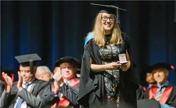  ?? Photos: USQ Photograph­y ?? ONWARDS AND UPWARDS: USQ morning ceremony Valedictor­ian Bethany Macdonald is applauded during her graduation.