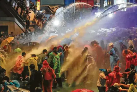  ?? Sakchai Lalit / Associated Press ?? Pro-democracy demonstrat­ors face water cannons as police try to clear a protest in Bangkok. Thailand’s prime minister has rejected calls for his resignatio­n as his government steps up efforts to stop student-led protesters from rallying in the capital.