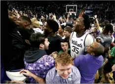  ?? AP photo ?? Kansas State forward Nae’Qwan Tomlin (35) celebrates with fans after the 13th-ranked Wildcats defeated No. 2 Kansas 83-82 in overtime on Tuesday.