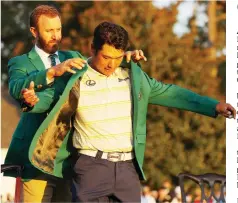  ?? — AFP photo ?? Hideki Matsuyama of Japan is awarded the Green Jacket by 2020 Masters champion Dustin Johnson of the United States during the Green Jacket Ceremony after he won the Masters at Augusta National Golf Club in Augusta, Georgia.