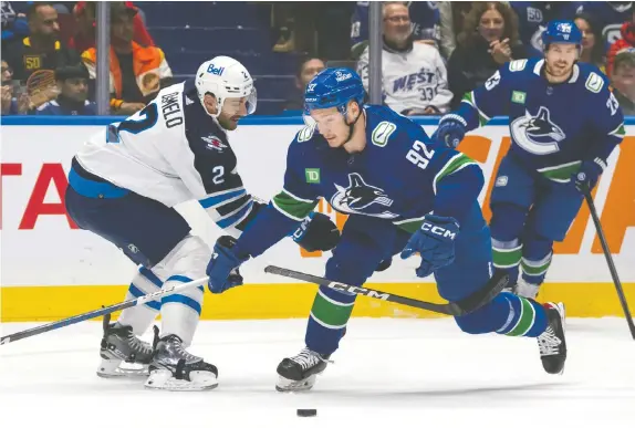  ?? ETHAN CAIRNS/THE CANADIAN PRESS FILES ?? Canucks' Vasily Podkolzin breaks the stick of the Jets' Dylan DeMelo as they vie for the puck during a game in Vancouver on March 9. The teams meet again Thursday night in Winnipeg in what is the Canucks' regular season finale.