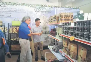  ??  ?? TAKLIMAT: Hafidz memberikan penerangan kepada Samat (kiri) mengenai produk yang dijual di BOS semasa mengadakan lawatan ke premis yang dilancarka­n semalam di Pusat Komersil Miri Waterfront.