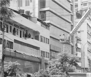  ??  ?? Bangladesh­i police stand guard at a hotel after a raid on a militant hideout in Dhaka. — AFP photo