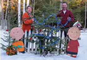  ?? ?? November marks the official start of holiday decorating season for Sean Weber (left) and Daniel Higgins (right). A section of chippy picket fence in their backyard serves as a background for a festive tree and “Peanuts” characters constructe­d by a Maine artist. “I’m a Christmas fanatic,” Daniel admits.