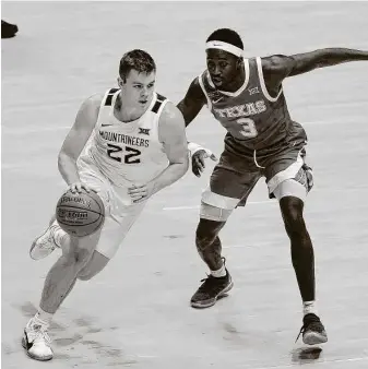  ?? Kathy Batten / Associated Press ?? Courtney Ramey guards West Virginia’s Sean McNeil on Jan. 9, when Texas improved to 10-1 with a big road victory. The Longhorns have lost four of five since then dealing with COVID-19 issues.