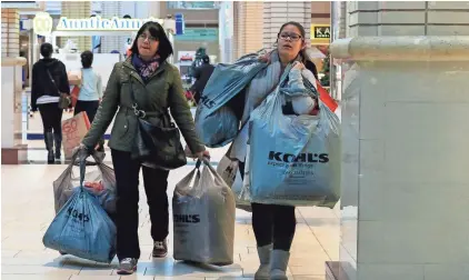  ?? KENA BETANCUR/GETTY IMAGES ?? Customers carry shopping bags at the Newport Mall during Black Friday sales Nov. 27, 2015, in Jersey City, N.J.