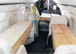  ?? MICHAEL GUTWEIN/ZAKA ?? A team member adjusts a coffin Wednesday in a plane at an airport in Israel.