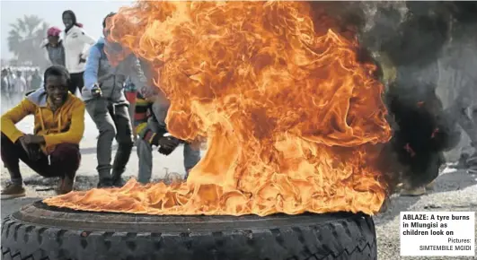  ?? Pictures: SIMTEMBILE MGIDI ?? ABLAZE: A tyre burns in Mlungisi as children look on