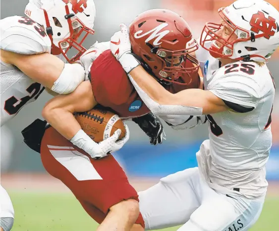  ?? DAVID GARRETT/SPECIAL TO THE MORNING CALL ?? North Central College’s Braden Lindmark, right, wraps up Muhlenberg’s Michael Feaster on Saturday afternoon during the NCAA Division III semifinal game. The Mules fell behind 35-0 in the second quarter and saw the finest season in program history come to an end one step shy of the Amos Alonzo Stagg Bowl.