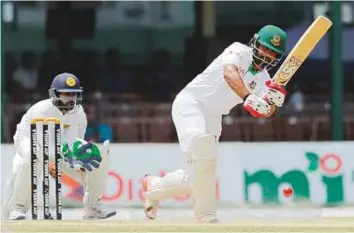  ?? AP ?? Bangladesh opener Tamim Iqbal flicks the ball off his pads during his 82 as Sri Lankan wicketkeep­er Niroshan Dickwella watches on during the fifth day of the second Test.