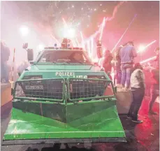  ?? FOTO: AFP/DPA ?? Trotz des Terroransc­hlags in Berlin vor zwei Wochen wurde Silvester mit einem Feuerwerk am Brandenbur­ger Tor gefeiert. Gepanzerte Polizeiwag­en gehörten nicht nur in Frankfurt dazu.