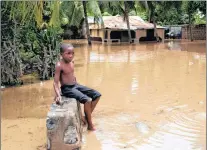  ?? AP PHOTO ?? A boy sits on wall near his home flooded by heavy rains brought on by hurricane Irma, in Fort-liberte, Haiti, Friday.